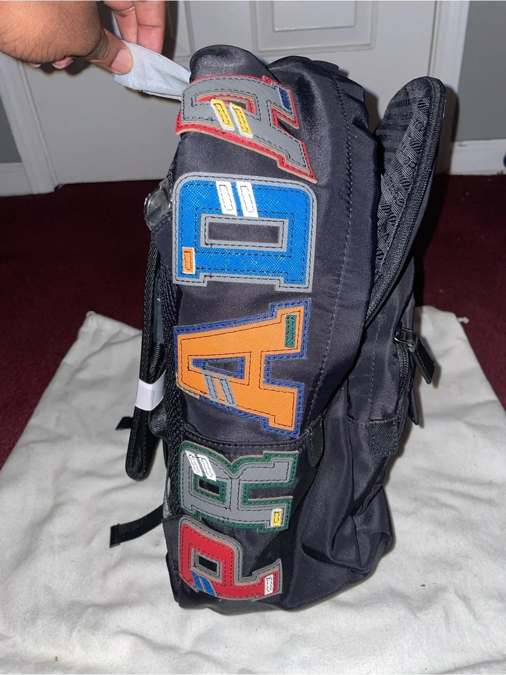 Prada Men’s Black Nylon Backpack with Multicolor Letter Patches